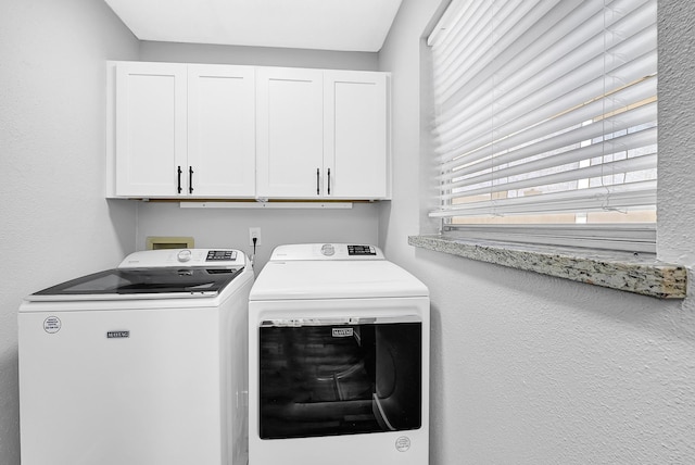 laundry area with separate washer and dryer and cabinet space