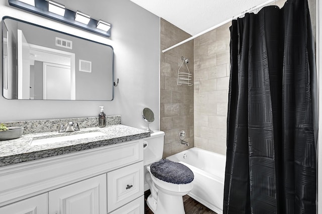 bathroom featuring visible vents, vanity, shower / tub combo, and toilet