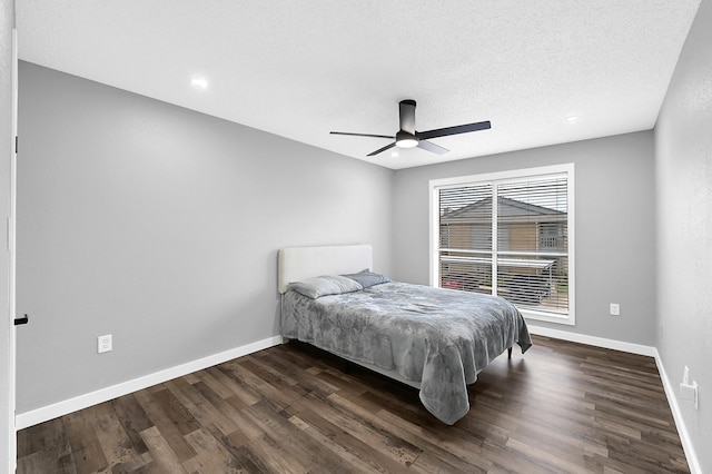 bedroom with a ceiling fan, dark wood-style floors, baseboards, and a textured ceiling