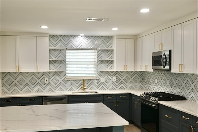 kitchen featuring visible vents, appliances with stainless steel finishes, white cabinetry, and a sink