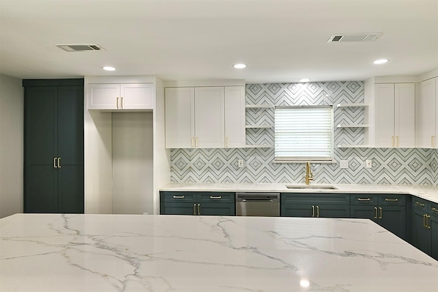 kitchen with stainless steel dishwasher, visible vents, a sink, and light stone counters