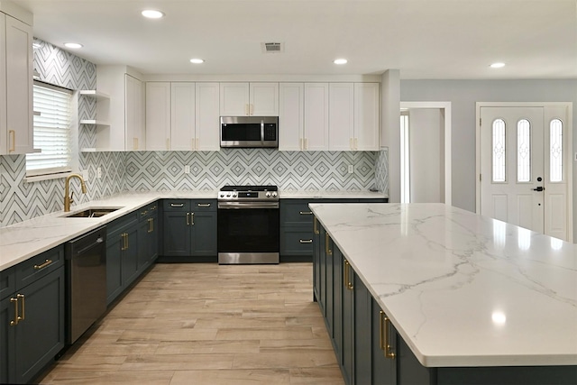 kitchen with a sink, open shelves, a center island, stainless steel appliances, and white cabinets