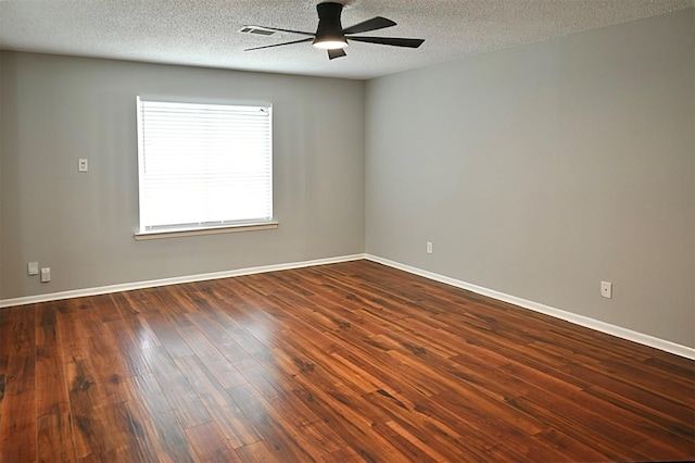 empty room with ceiling fan, baseboards, a textured ceiling, and dark wood-style floors