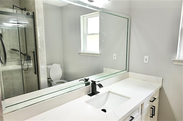 full bath with vanity, toilet, and a stall shower