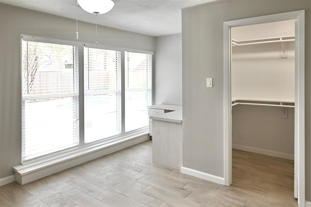 interior space with plenty of natural light, baseboards, and wood finished floors