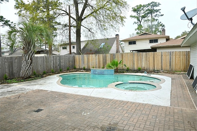 view of swimming pool featuring a patio, a fenced backyard, and a pool with connected hot tub