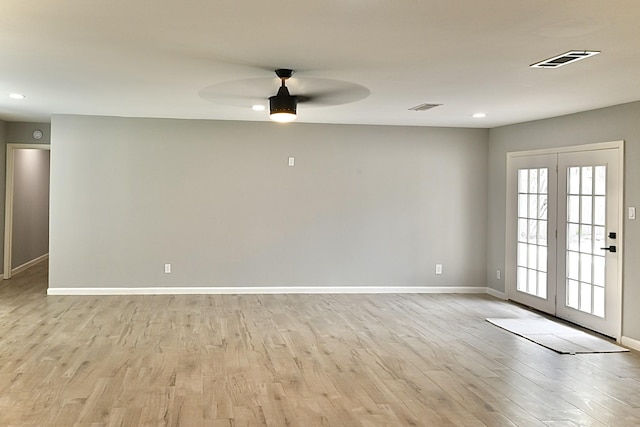 unfurnished room with light wood-style flooring, a ceiling fan, visible vents, and baseboards