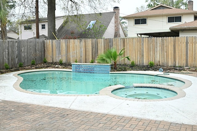 view of swimming pool featuring a fenced backyard and a pool with connected hot tub