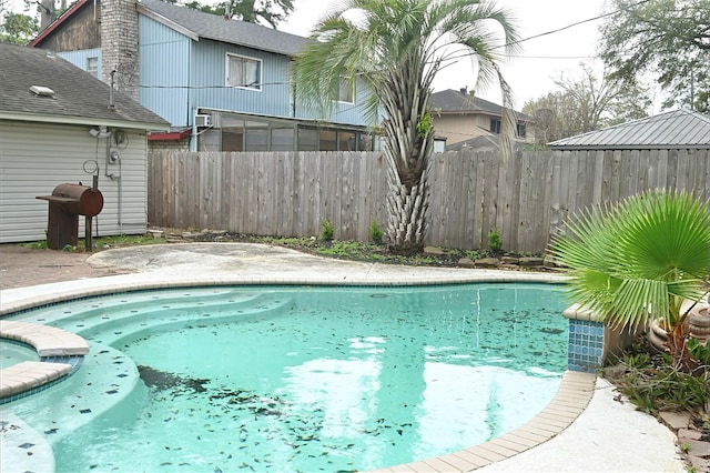 view of swimming pool with a pool with connected hot tub and fence