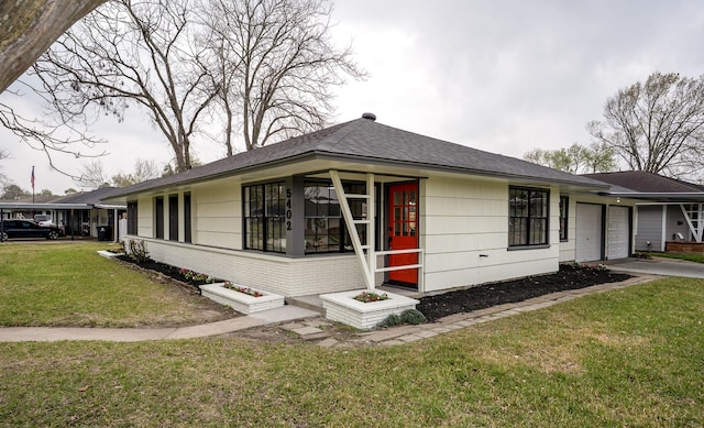 ranch-style house with brick siding, a front yard, a garage, and roof with shingles