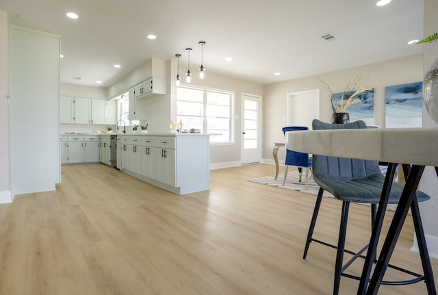 kitchen featuring visible vents, light wood finished floors, stainless steel dishwasher, recessed lighting, and light countertops