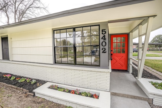 entrance to property featuring brick siding