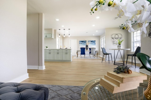 living room with recessed lighting, baseboards, and light wood finished floors