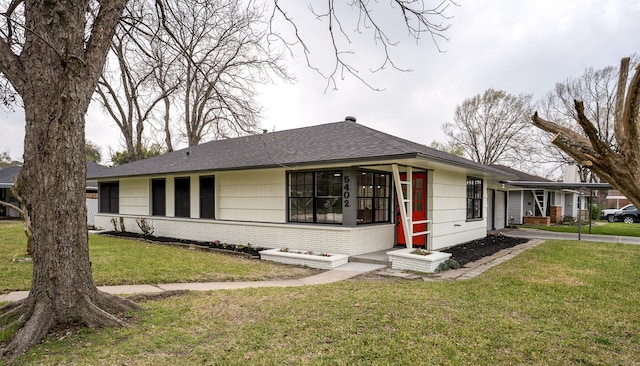 single story home featuring a front yard, brick siding, and a shingled roof