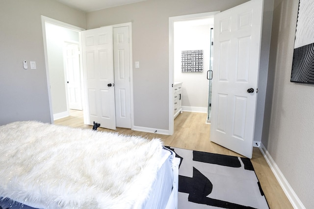 bedroom with light wood-style flooring and baseboards