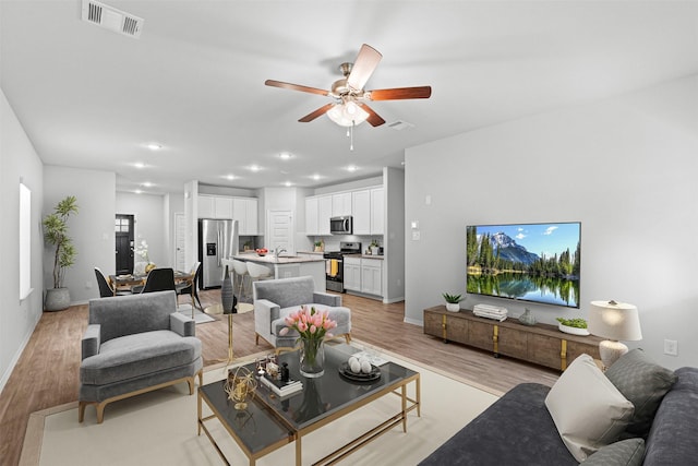 10718 Soapberry Ct, Tomball, TX 77375 - living area featuring visible vents, light wood-style floors, baseboards, recessed lighting, and a ceiling fan