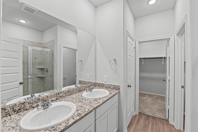 10718 Soapberry Ct, Tomball, TX 77375 - full bath with visible vents, a shower stall, a sink, and wood finished floors