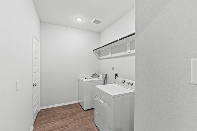 10718 Soapberry Ct, Tomball, TX 77375 - laundry room with laundry area, visible vents, wood finished floors, baseboards, and washer and dryer