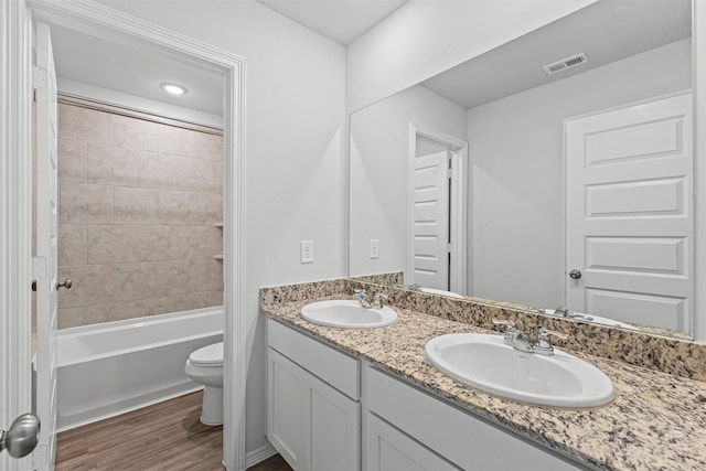 10718 Soapberry Ct, Tomball, TX 77375 - full bath with visible vents, a sink, wood finished floors, and toilet