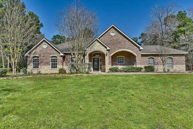 ranch-style house with a front yard and brick siding