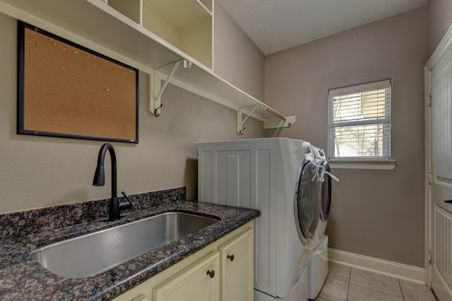 laundry room with baseboards, washing machine and dryer, light tile patterned flooring, cabinet space, and a sink