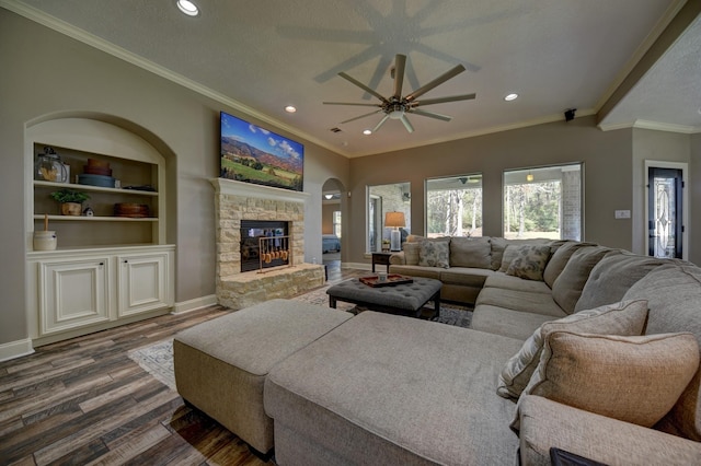 living area featuring a fireplace, dark wood-style floors, baseboards, and ceiling fan