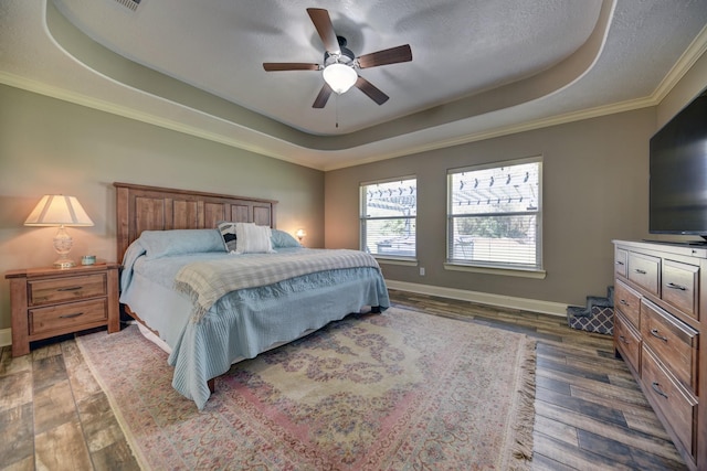 bedroom featuring a tray ceiling, baseboards, and dark wood-style flooring