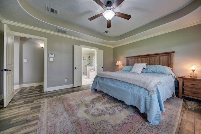 bedroom featuring visible vents, baseboards, a tray ceiling, and wood finished floors