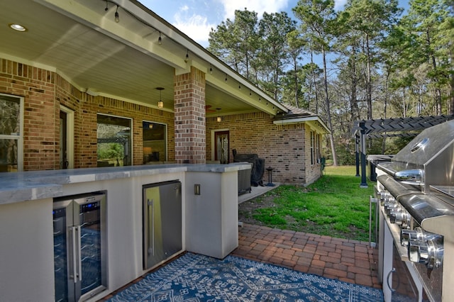 view of patio / terrace featuring wine cooler, central air condition unit, and exterior kitchen