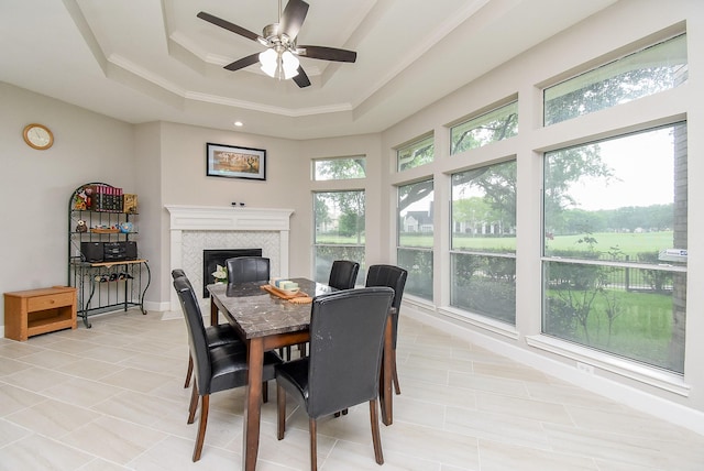 3211 Riviera Dr, Sugar Land, TX 77479 - dining space with baseboards, ceiling fan, light tile patterned floors, a fireplace, and a raised ceiling