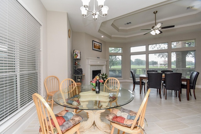 3211 Riviera Dr, Sugar Land, TX 77479 - dining space with visible vents, a tray ceiling, a fireplace, ornamental molding, and ceiling fan with notable chandelier