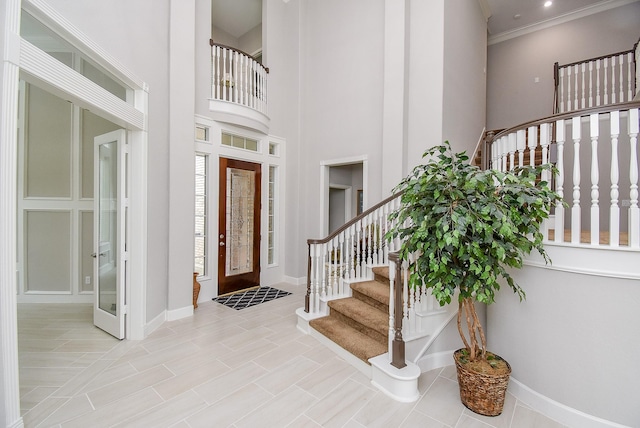 3211 Riviera Dr, Sugar Land, TX 77479 - entryway featuring stairway, baseboards, a towering ceiling, and ornamental molding