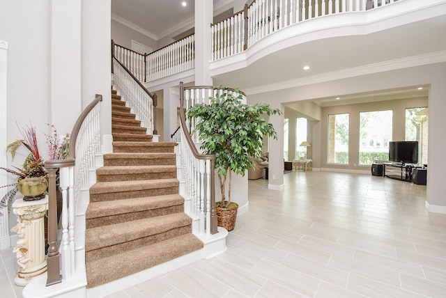 3211 Riviera Dr, Sugar Land, TX 77479 - stairway featuring recessed lighting, baseboards, a towering ceiling, and ornamental molding