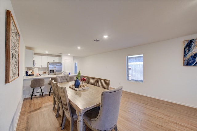 dining space with light wood-style flooring, recessed lighting, visible vents, and baseboards