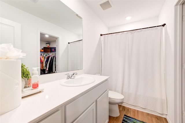 full bathroom featuring visible vents, toilet, shower / tub combo, wood finished floors, and vanity