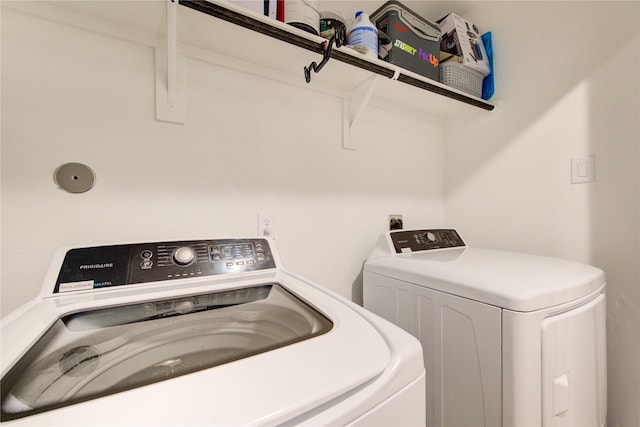 clothes washing area featuring independent washer and dryer and laundry area