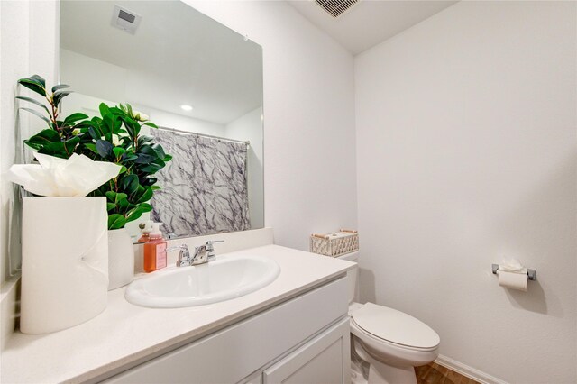 bathroom with vanity, curtained shower, toilet, and visible vents