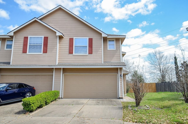 view of property with driveway, a front lawn, an attached garage, and fence