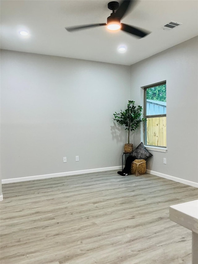 empty room featuring visible vents, baseboards, a ceiling fan, and wood finished floors