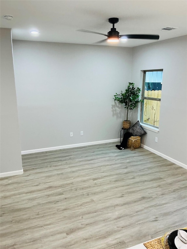 empty room with visible vents, baseboards, wood finished floors, and a ceiling fan