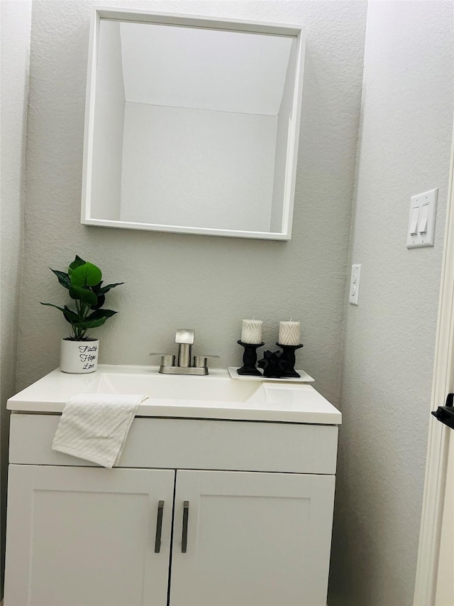 bathroom with vanity and a textured wall