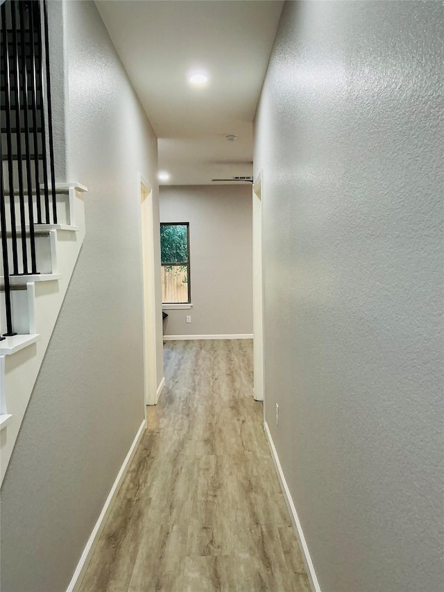 corridor with wood finished floors and baseboards