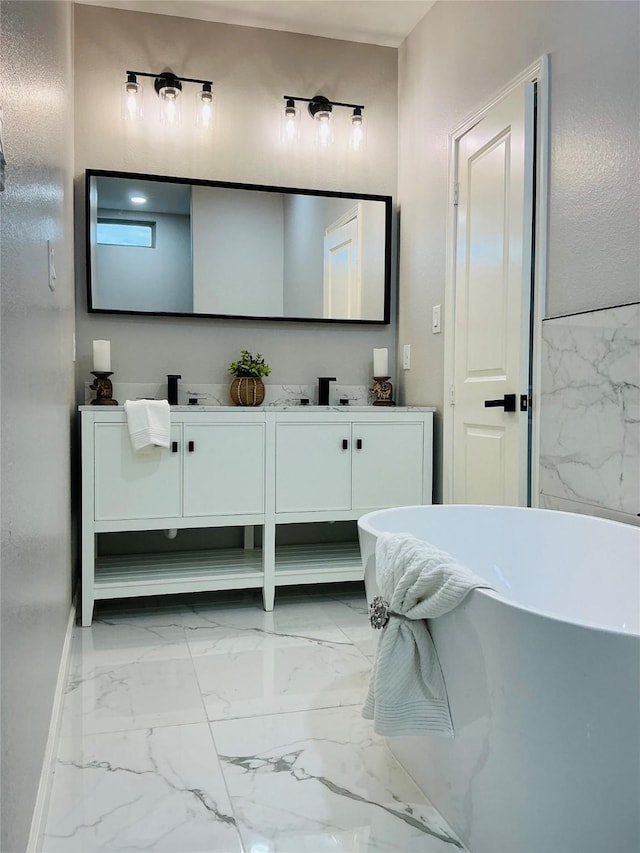 bathroom featuring marble finish floor, a freestanding tub, and double vanity