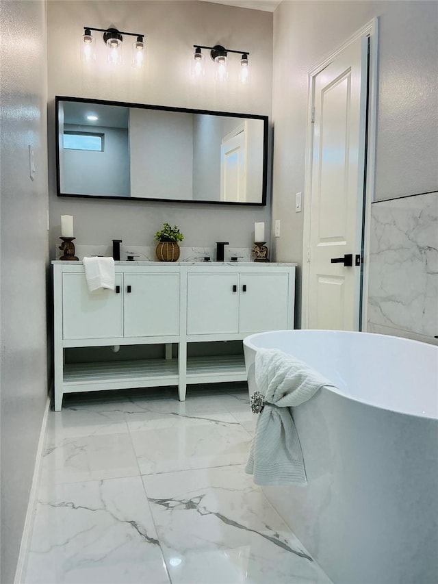 bathroom with double vanity, a soaking tub, and marble finish floor