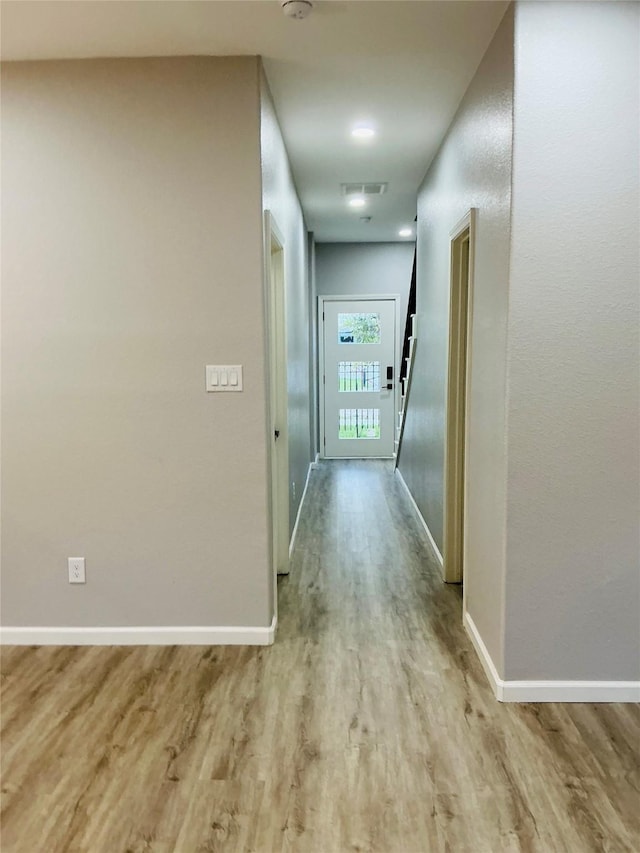 hallway with baseboards and wood finished floors