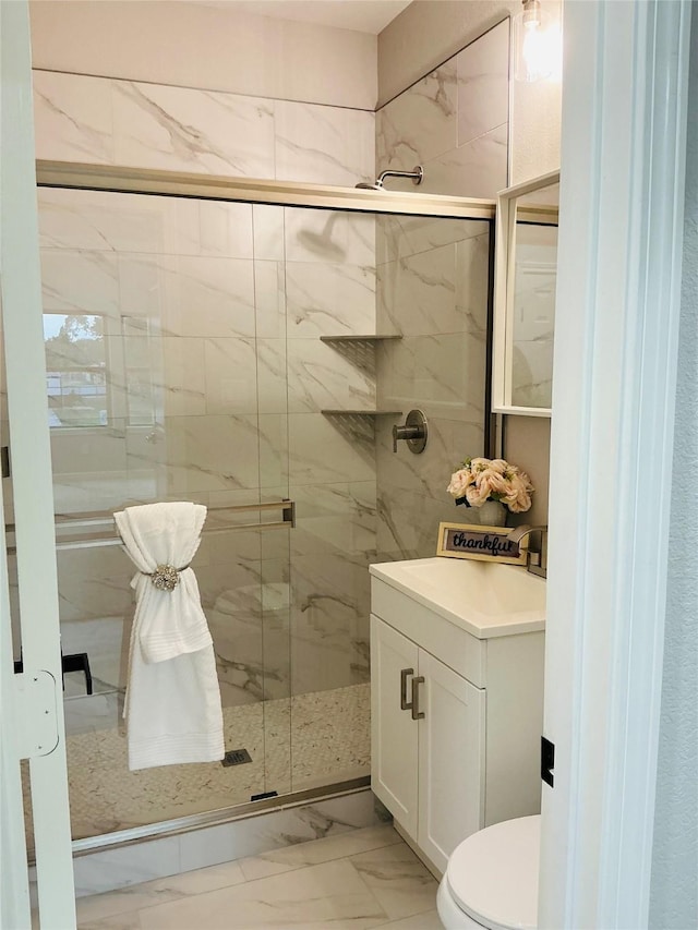 bathroom featuring vanity, marble finish floor, a shower stall, and toilet