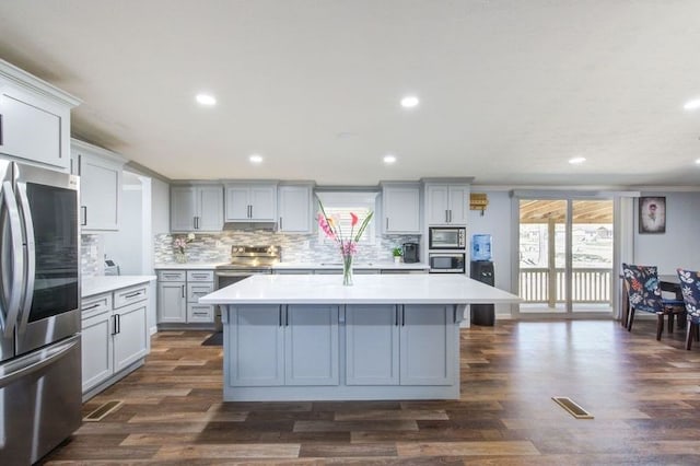 kitchen featuring a center island, gray cabinets, stainless steel appliances, and light countertops