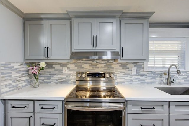 kitchen with gray cabinetry, stainless steel electric range, and exhaust hood