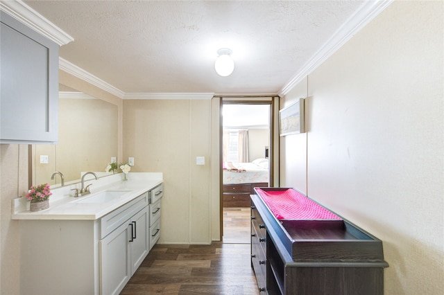 bathroom with connected bathroom, vanity, wood finished floors, and crown molding