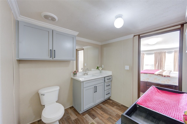 bathroom featuring vanity, wood finished floors, visible vents, ensuite bath, and toilet